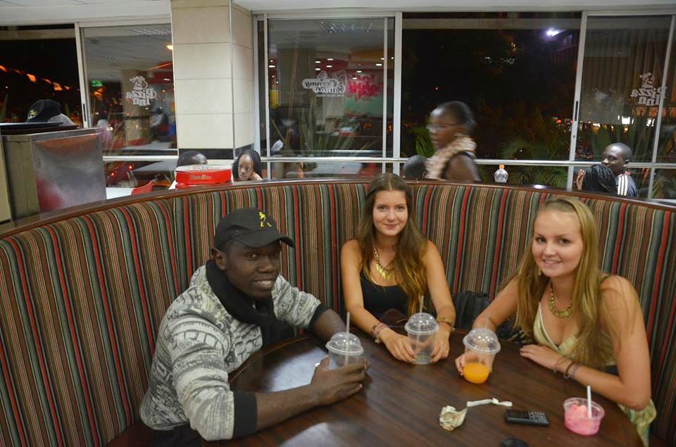Volunteers and friends gathered around a restaurant table in Kenya