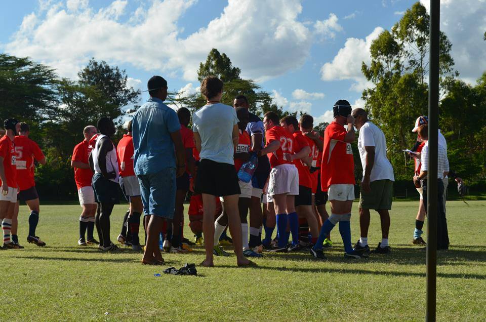 Volunteers and players gathered on a sports field in Kenya